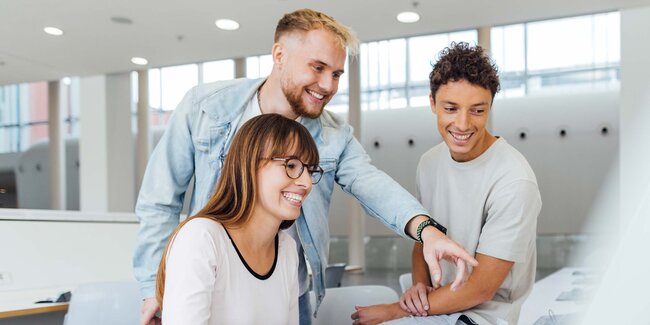 Group of young people looking at something on the computer